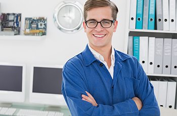 Smiling technician looking at camera in his office